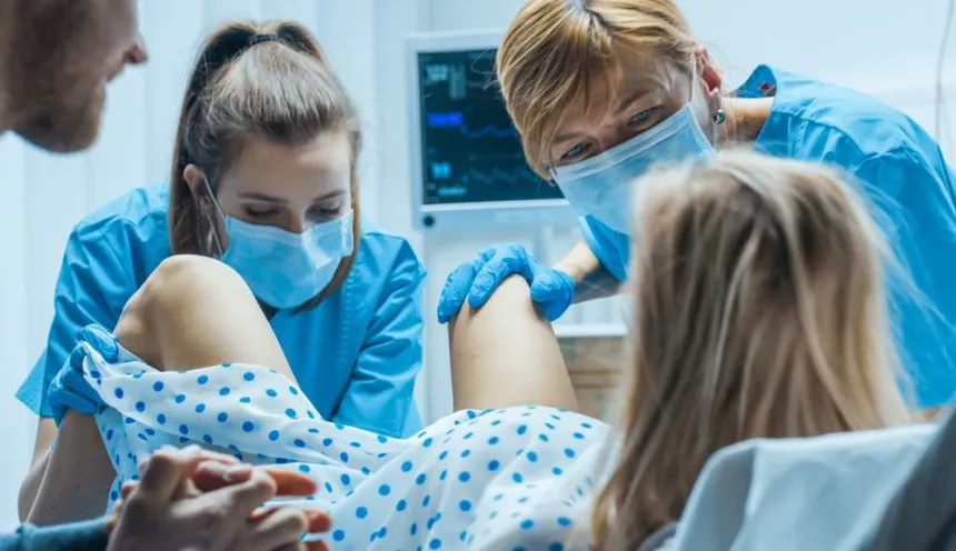 sage-femme échographiste en train d'accoucher une primipare en milieu hospitalier